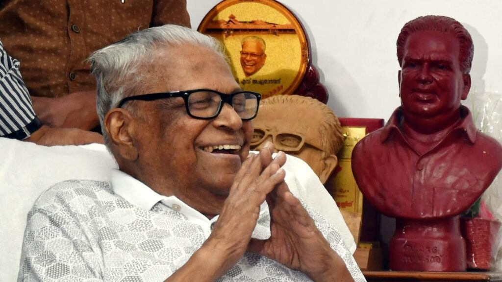 V.S. Achuthanandan seated during a political event, wearing traditional white attire and spectacles