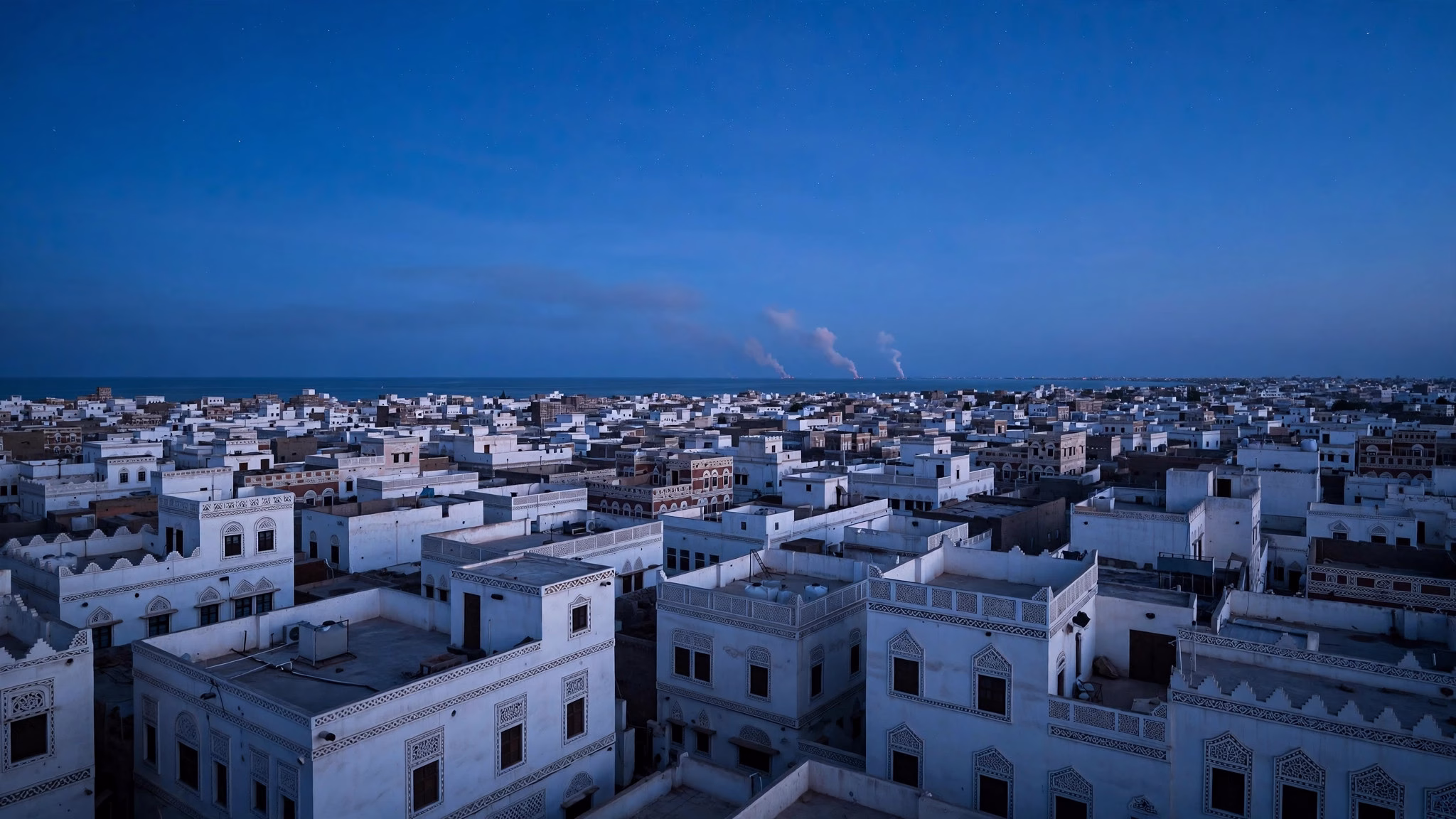 Aerial view of a coastal Middle Eastern port city at dusk