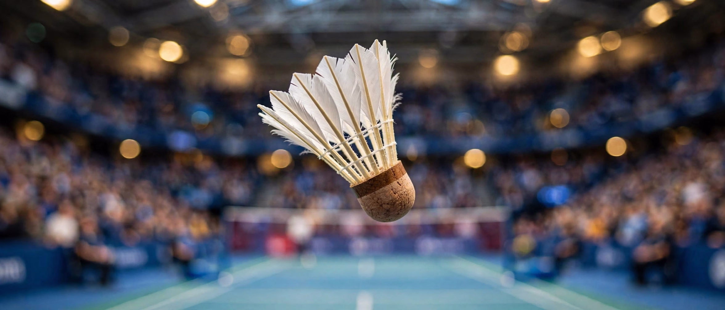 Badminton shuttlecock frozen mid-flight above a Paris arena court